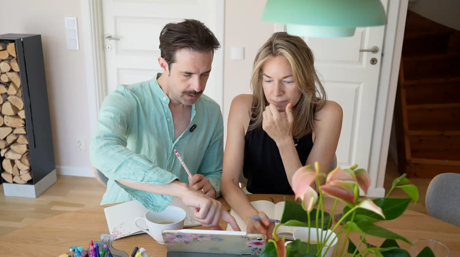 Erika and Martin studying together at the table with notebooks and a tablet